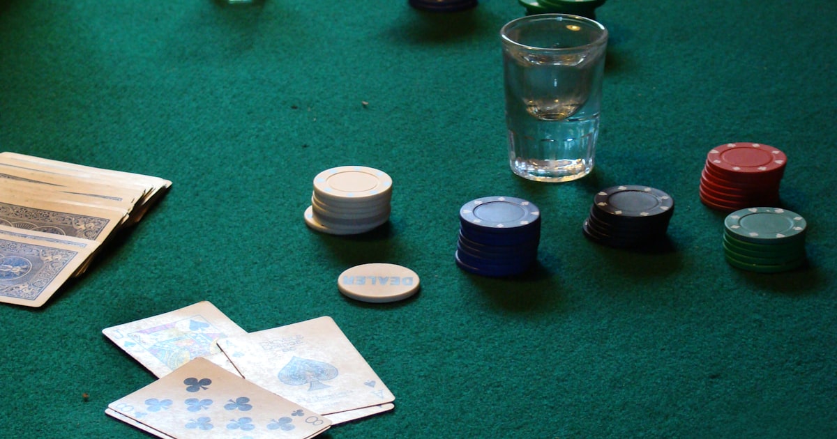 Poker table with chips stacked and playing cards spread on green felt